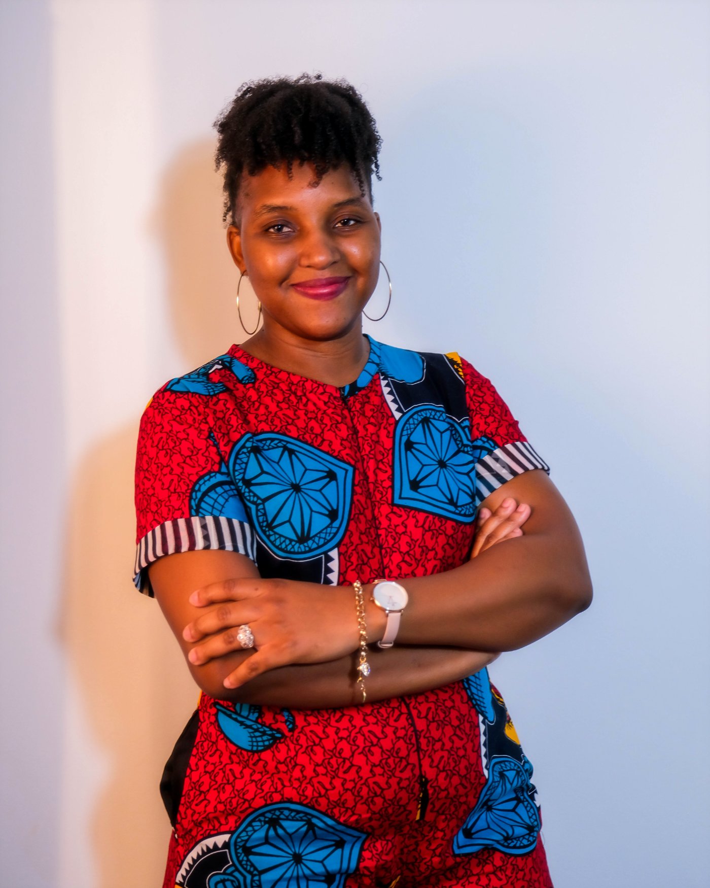 Tawanda R. S. Kamuna standing with arms folded against a plain wall